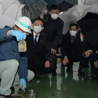 南蒲生浄化センターの採水現場を視察する塩田氏（左から2人目）ら＝11日　仙台市